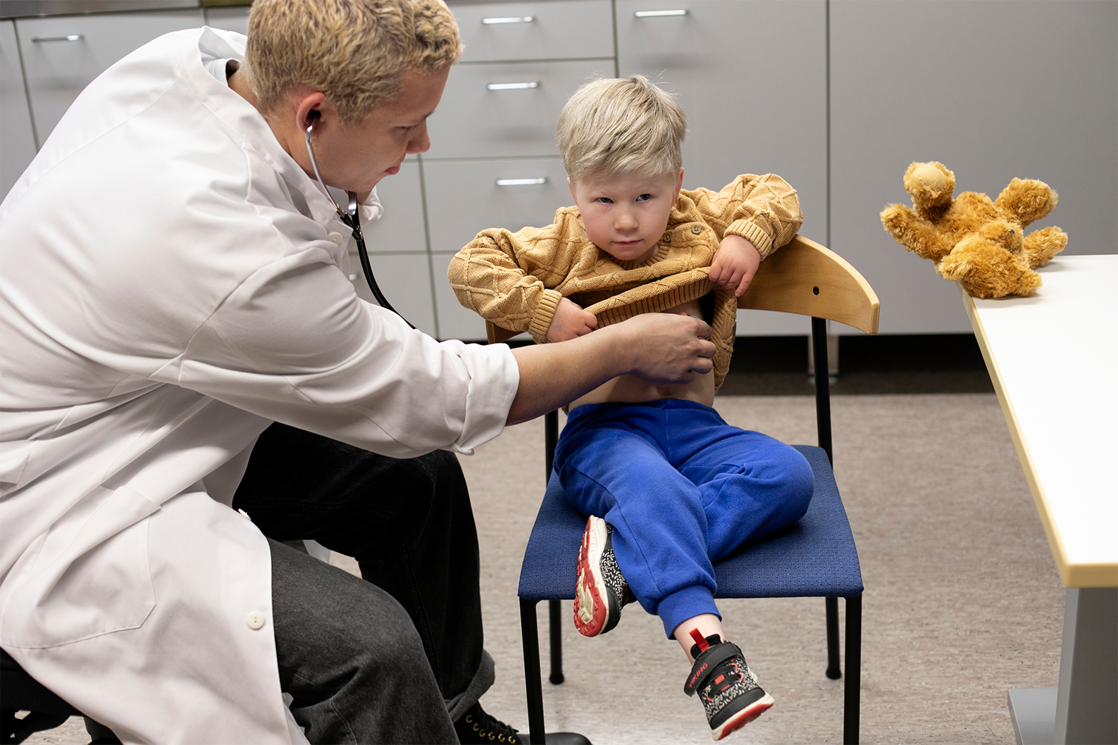 D-resepti Pro:ta käyttävä lääkäri omalla vastaanotollaan, tutkii stetoskoopilla pientä lasta.