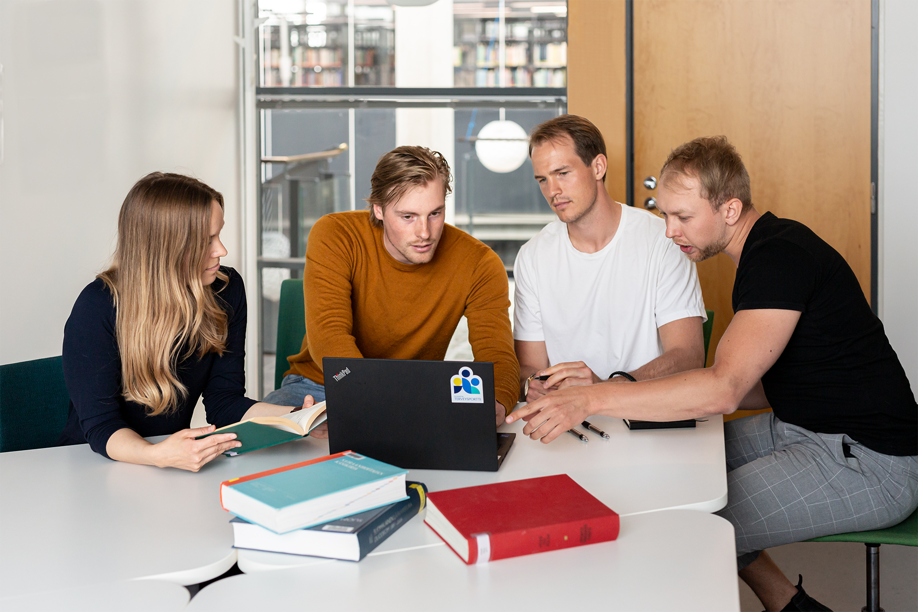 Neljä lääketieteen opiskelijaa tietokoneen ääressä, käyttävät D-mentoria opiskelun tukena.