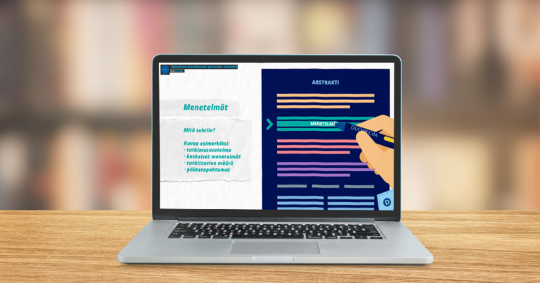 Tietokone puupöydällä, taustalla sumeana näkyvä kirjasto. Tietokoneen näytöllä näytönkaappauskuva Tutkijaportin tieteellisen kirjoittamisen opetusvideosta.