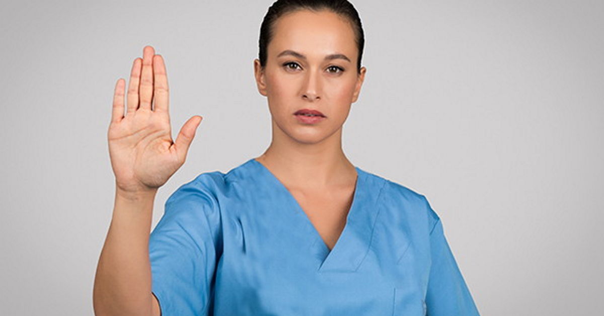 Hoitaja käsi ylhäällä stop-merkiksi