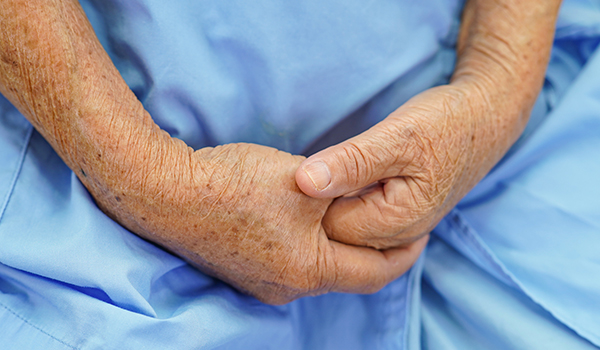 Vanhus kädet vartalon edessä